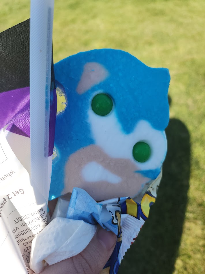 An image of a Sonic the Hedgehog ice cream popsicle. The eyes are gumballs, and the rest of the popsicle is in blue and tan colors.